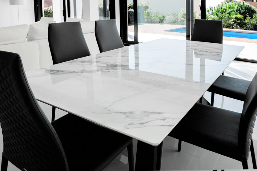 Dining room with black chairs, and table surface made of bookmatched quartz slab