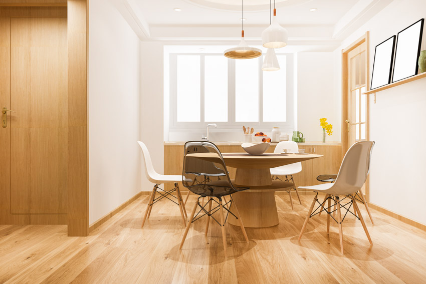 Dining room with chairs, table, birch wood floors, pendant lights, cabinets, door, and windows