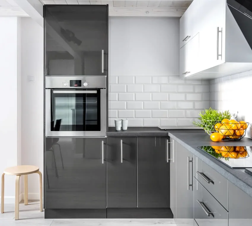 An elegant kitchen with brick tile backsplash, built in oven and modern cupboards