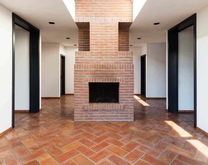 Empty hallway with brick floor, and fireplace