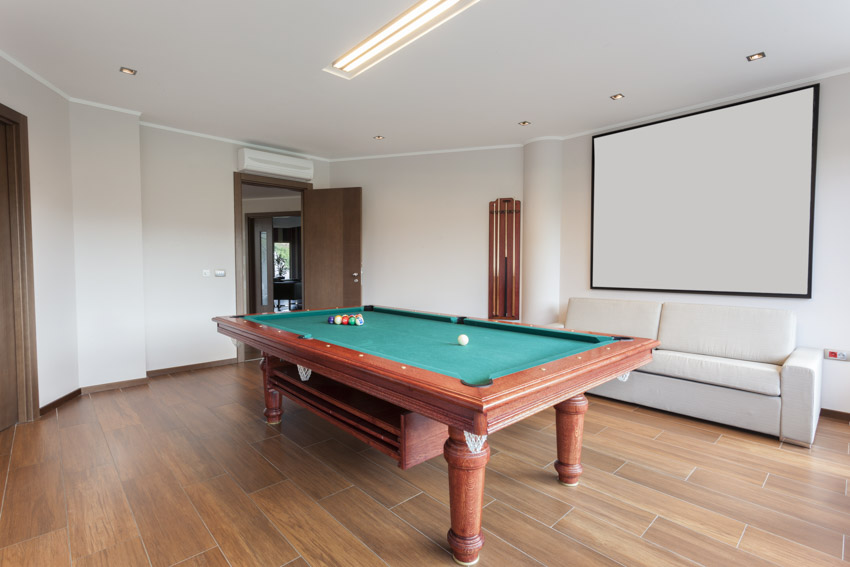 Room with pool game, white walls, couch, and luxury vinyl floor