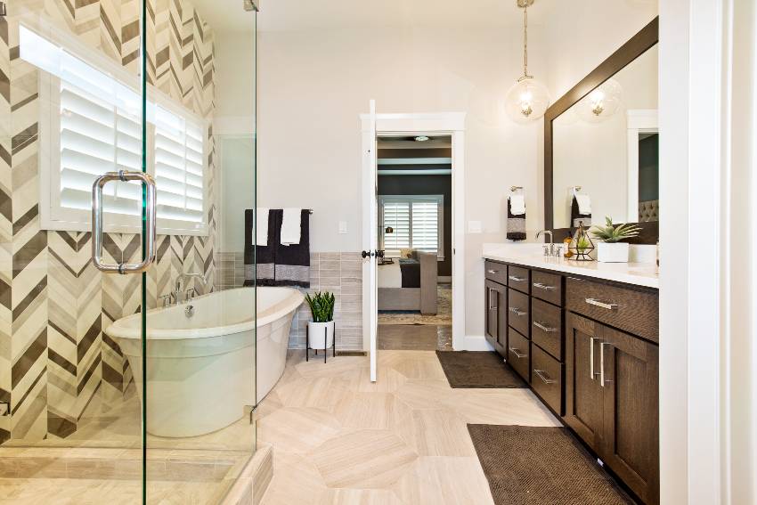 Gorgeous bathroom with bathtub, wooden cabinets, tile floors and vinyl wallpaper accent wall