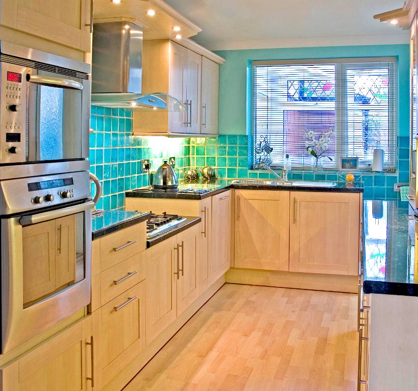 Gorgeous tiny kitchen with blue green tiled backsplash, wooden floors and rift sawn white oak cabinets