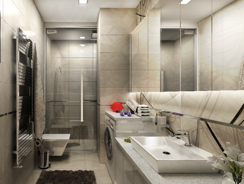 A grey tiled bathroom interior with toilet, sink, washer dryer and shower with glass doors and tiled ceiling