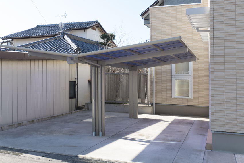House carport with angled roof, and concrete driveway
