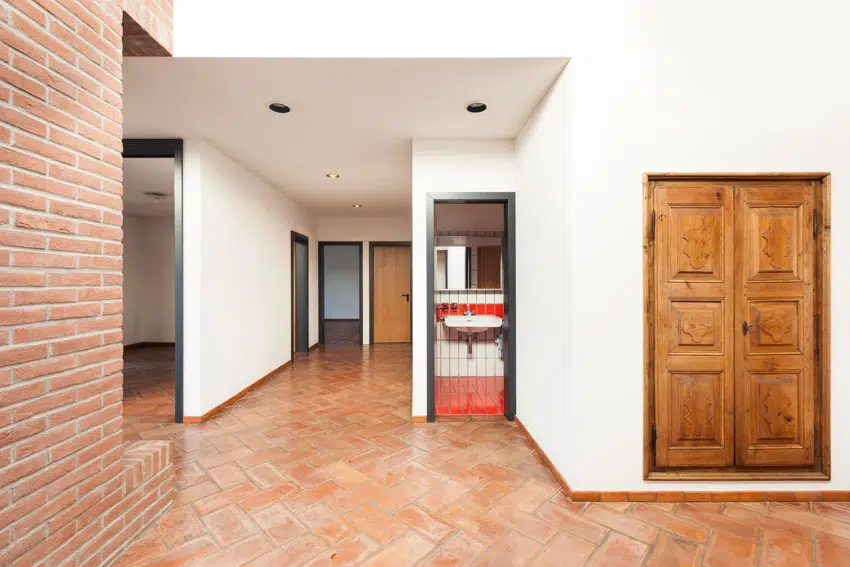 House interior with brick pattern floor, decorative door, and accent wall