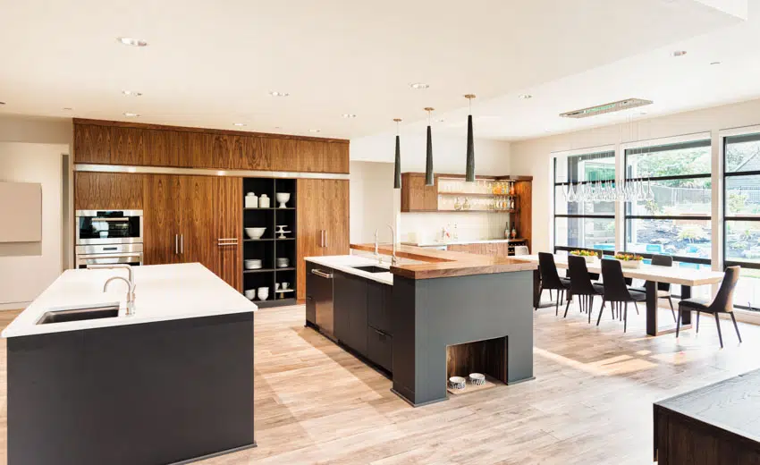 Kitchen and dining room combined with center island, Walnut cabinets, table, chairs, pendant lights, and windows