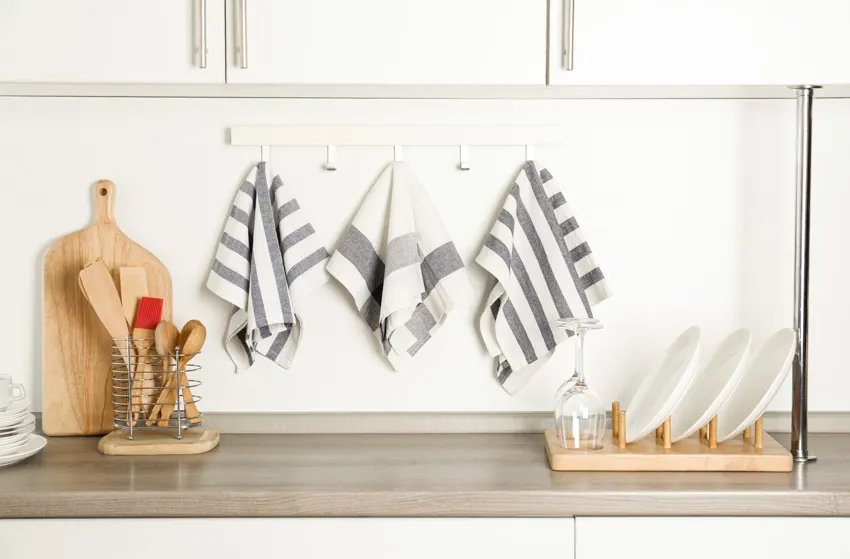 Kitchen area with countertop, cutting board, plates, and kitchen towels