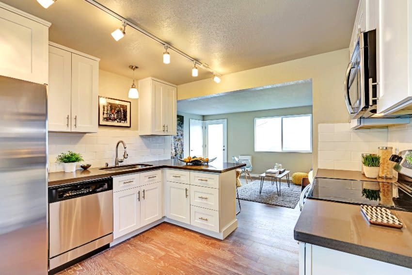 Kitchen with track lights, overhead cupboards and beige walls