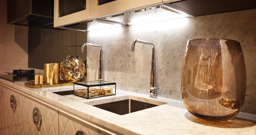 Kitchen with Taj Mahal quartzite countertop, backsplash, sink, and faucets