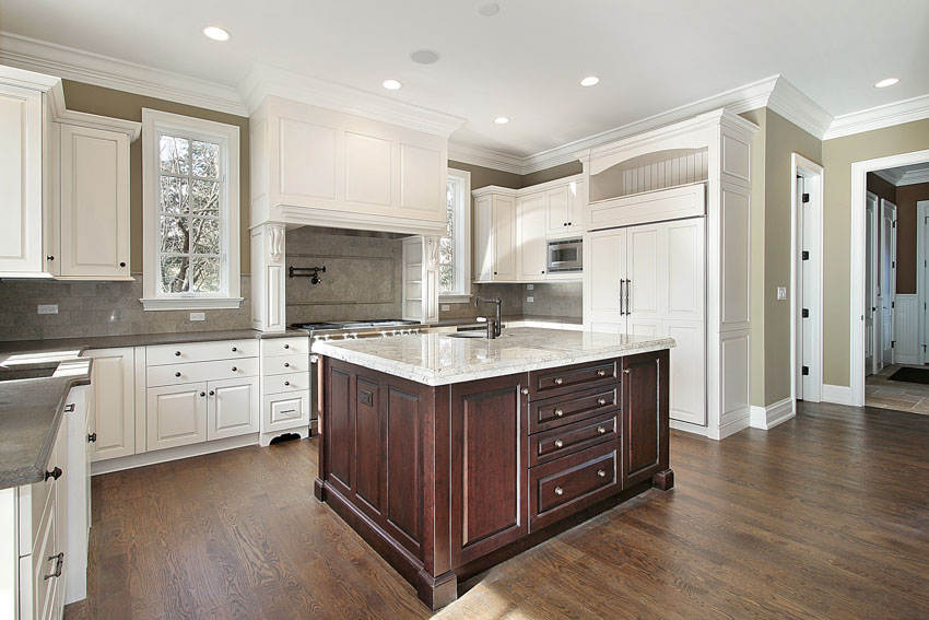 Kitchen with Taj Mahal quartzite countertop, wood floor, backsplash, white cabinets, and window