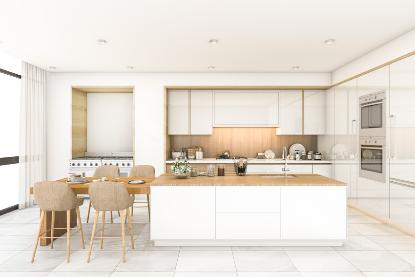 Kitchen with bamboo backsplash, center island, wood countertop, table, chairs, and cabinets