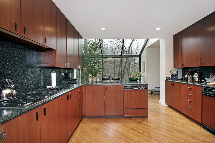 Kitchen with cherry cabinets, wood flooring, granite backsplash, countertops, and ceiling lights