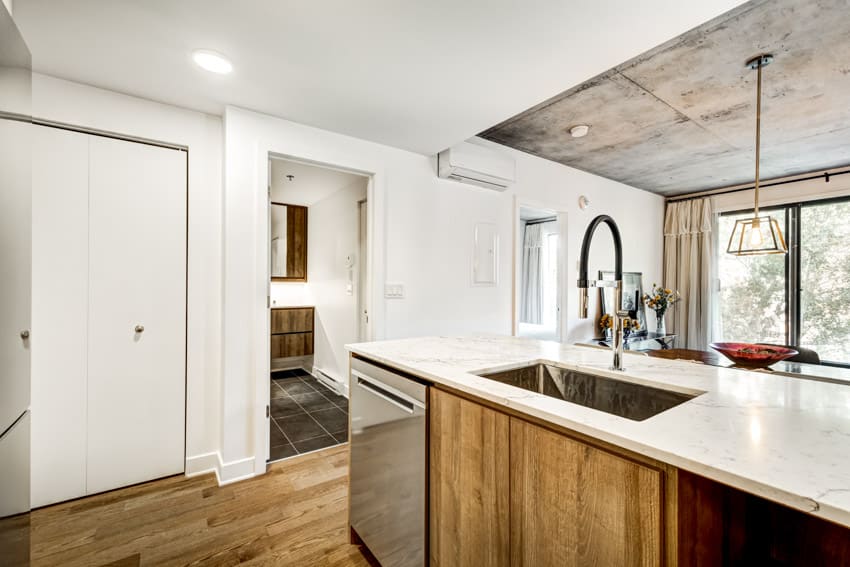 Kitchen with countertop, sink, faucet, ceiling light, and wood flooring