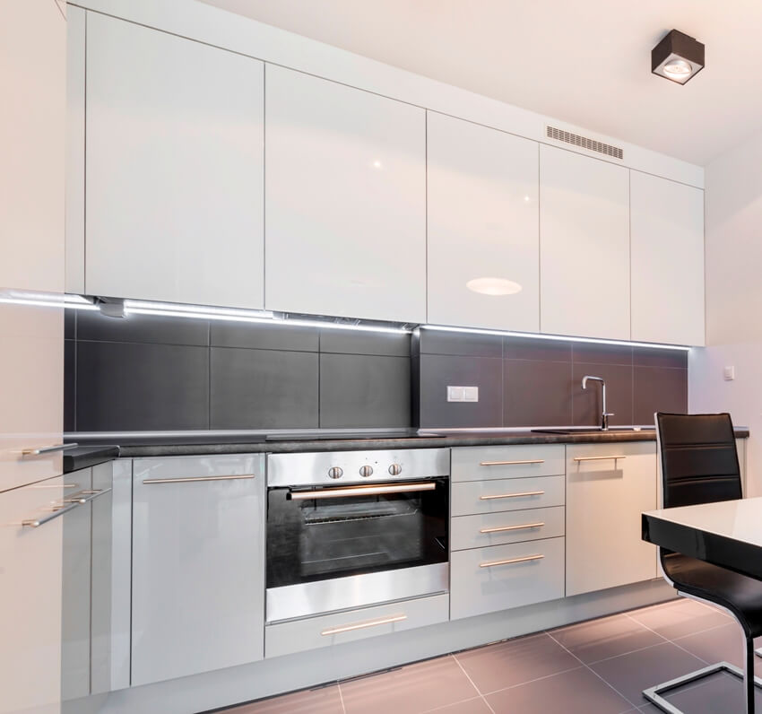 Kitchen with built in stove, steel cabinets and dark paint backsplash