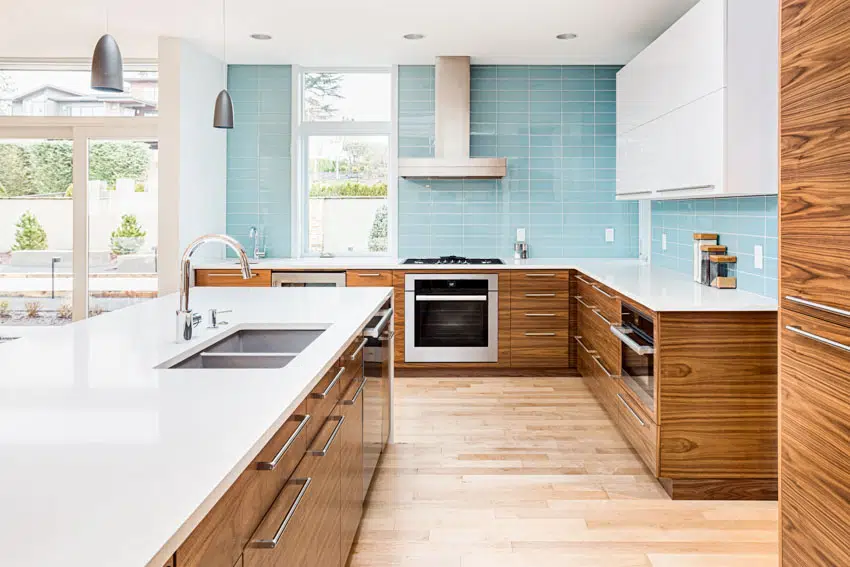 Kitchen with grain-matched Walnut cabinets, tile backsplash, countertops, sink, faucet, range hood, oven, and windows