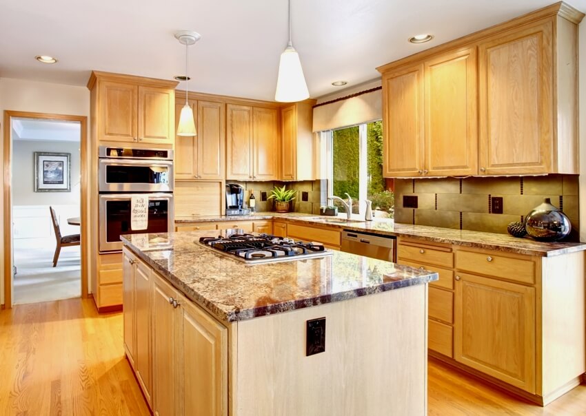 Kitchen with hardwood floors, cabinets and built in stove on glossy granite island counter 