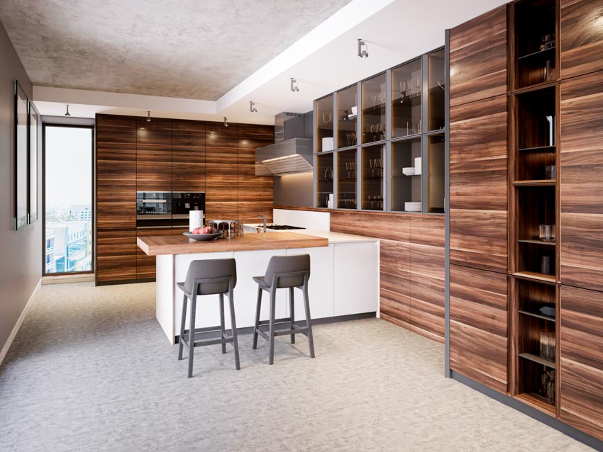 Kitchen with horizontal wood grain cabinets, chairs, peninsula seating, wood countertop, range hood, oven, and ceiling lights