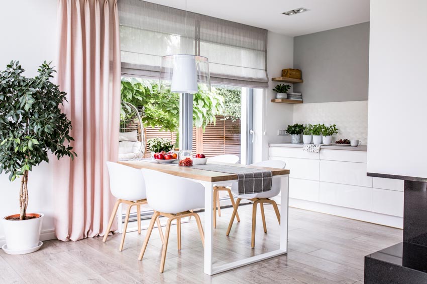 Kitchen with magnetic Roman shades, table, chairs, pink curtain, indoor plant, and wood floor