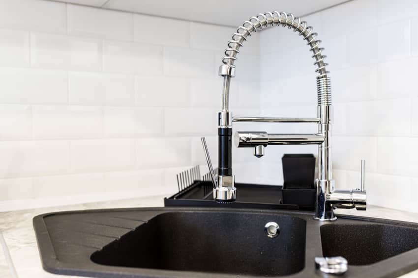 Kitchen with tile backsplash, countertop, and faucet