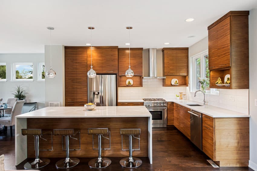 Kitchen with walnut cabinets, island, bar stools, countertops, wood floor, and ceiling lights