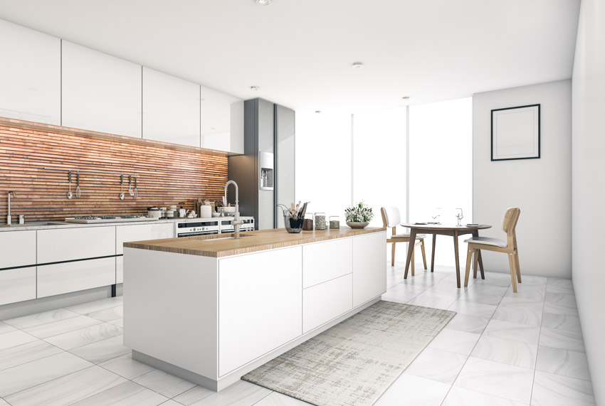 Kitchen with white cabinets, bamboo backsplash, island, countertop, tile floors, table, chairs, and window