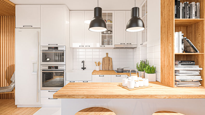 Kitchen with wood countertops, hanging lights, white cabinets, peninsula seating, tile backsplash, oven, and open shelves