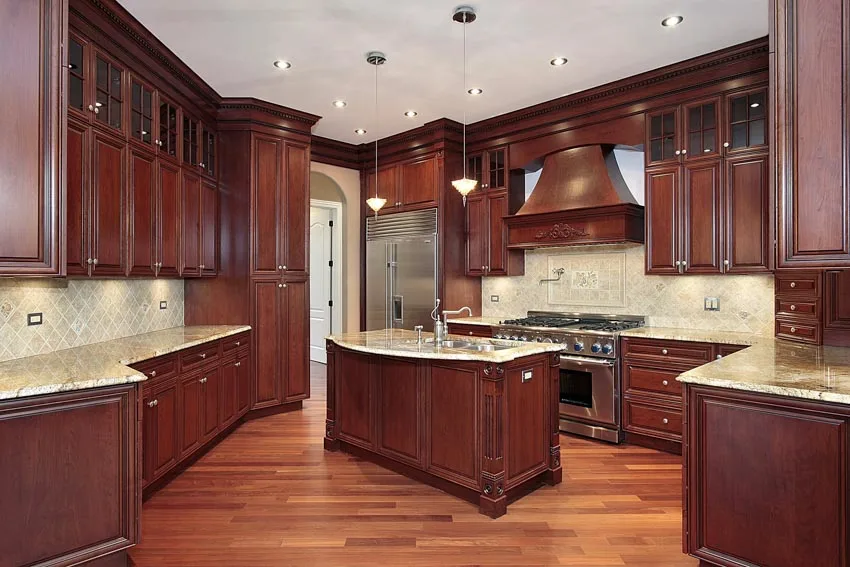 Kitchen with wooden floors and diagonal tile backsplash and wooden hood