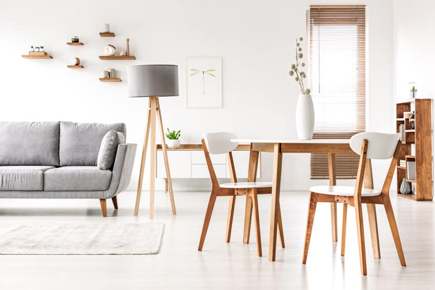 Open space layout with couch, floor rug, lamp, table and chairs