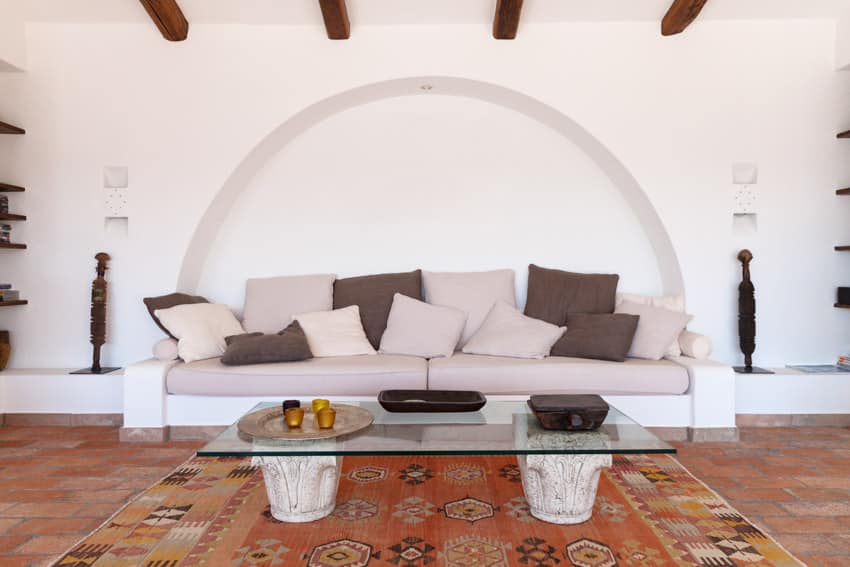 Spanish style living room with red brick floor and large area rug