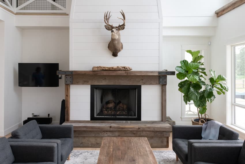 Wood burning fireplace with custom wood mantle and shiplap accent wall