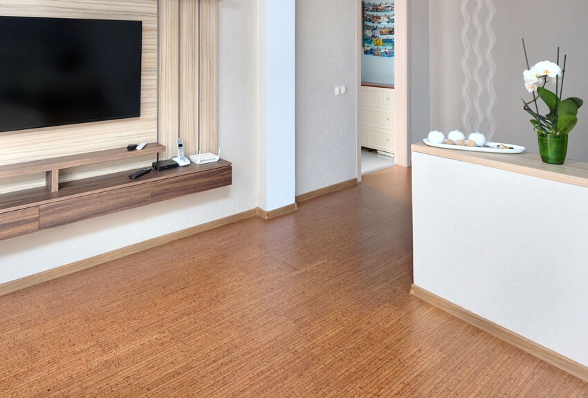 Minimalist room design with large tv over wooden floating counter and cork flooring