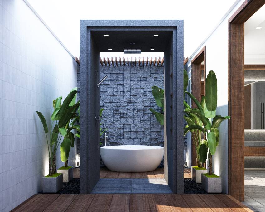 A modern bathroom with stone accent wall tiles, wooden floors and plants on the side