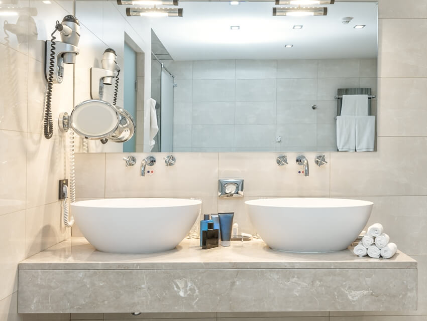 Modern luxury bathroom with two sinks, hairdryer and towels