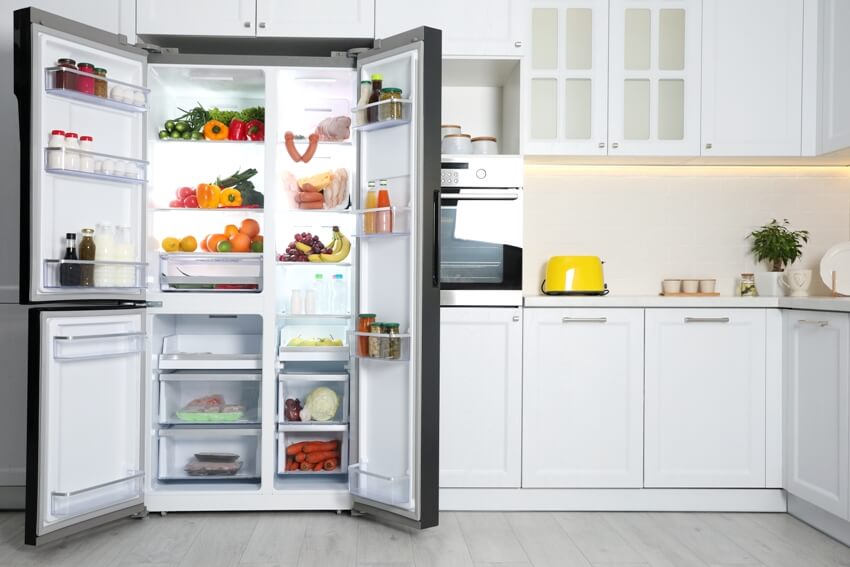 An open organized refrigerator filled with food in kitchen