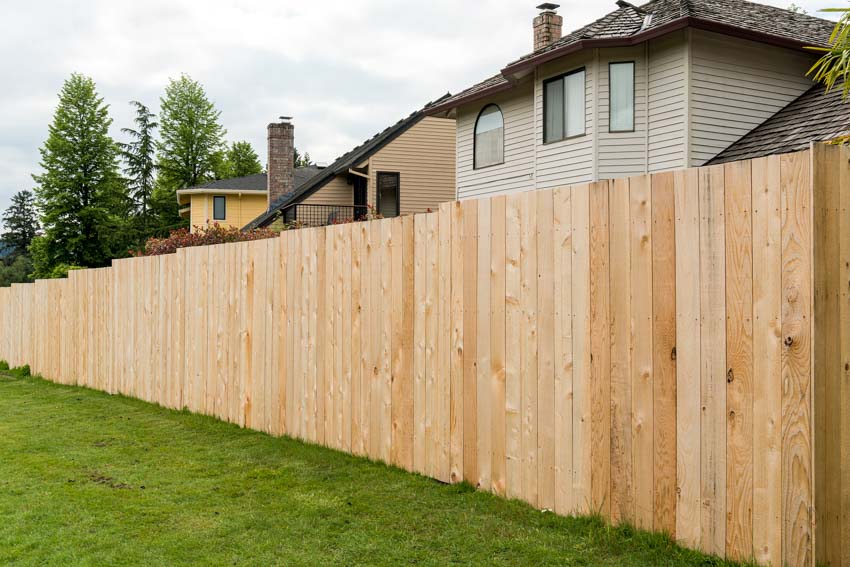 Outdoor area with cedar side by side fence with a house behind it