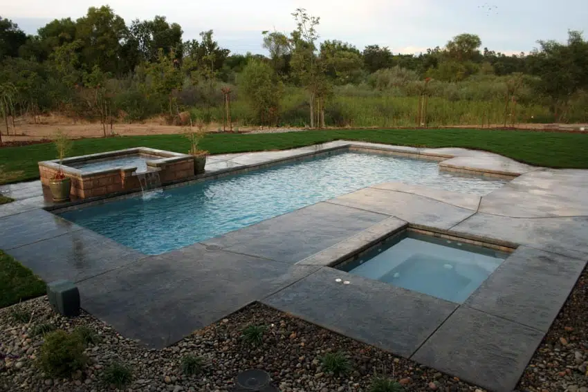 Outdoor area with gunite pool, concrete deck, and hot tub