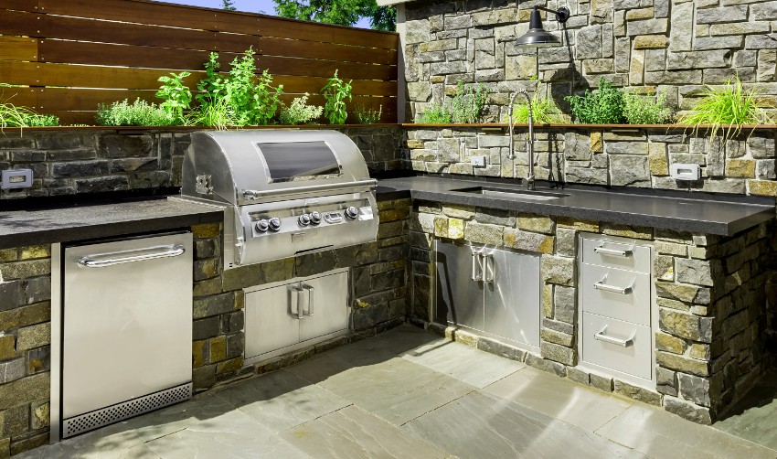 Outdoor kitchen with bluestone countertop, barbeque griller and sink
