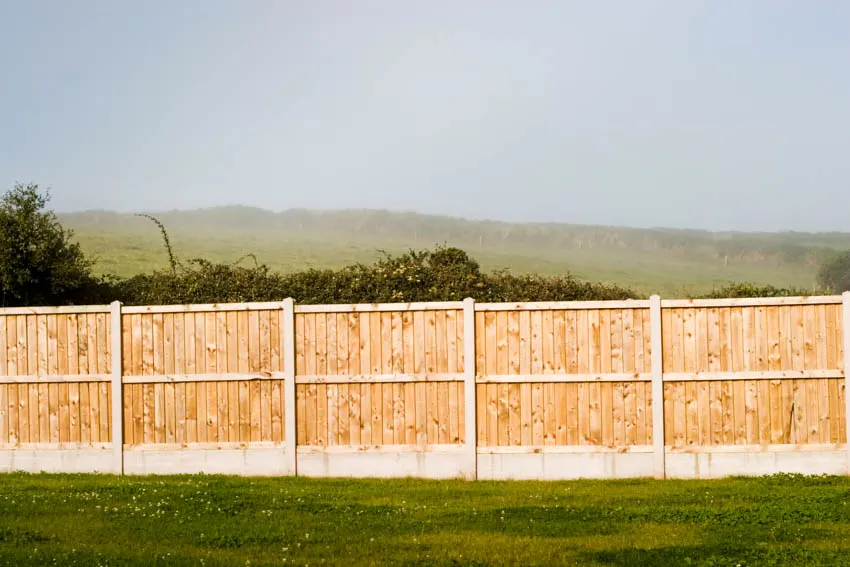 Overlapping fence panels for residential properties with a grassy area