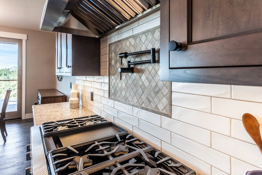 Peel and stick backsplash in white finish and countertop stove on granite countertop