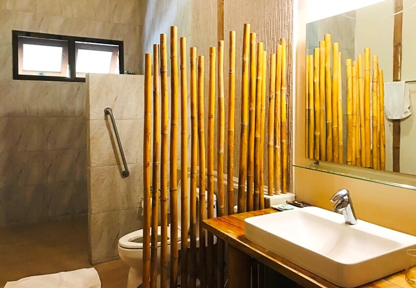 Small bathroom with bamboo wall divider separating toilet and sink