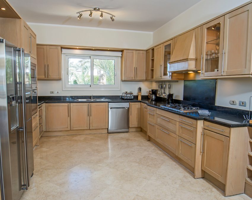 Spacious kitchen with tiled floors, stainless steel appliances and white oak wood cabinets