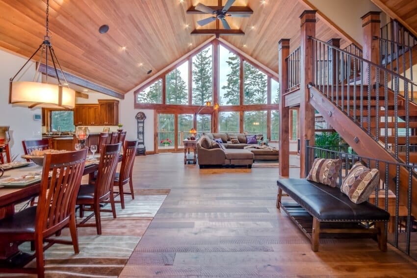 Stunning wooden mountain home interior with huge sofa, ceiling fan and red pine wood flooring