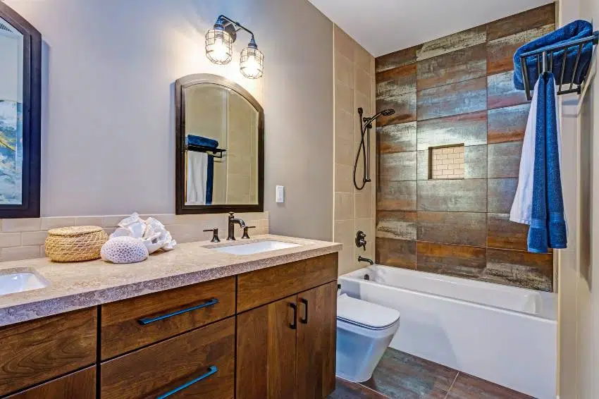 Stylish bathroom interior with double vanity cabinet, natural stone tiled floor, and wood accent wall