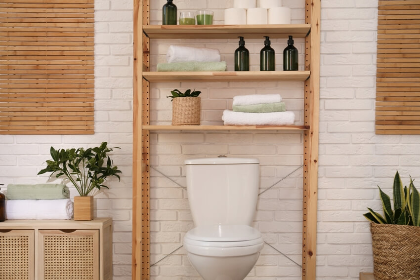 Stylish bathroom interior with toilet bowl, clean set of towels and basic hygiene supplies