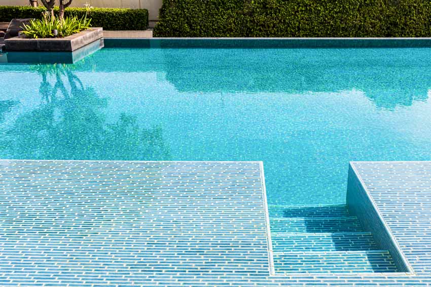 Swimming pool with ceramic tile finish, steps, and deck
