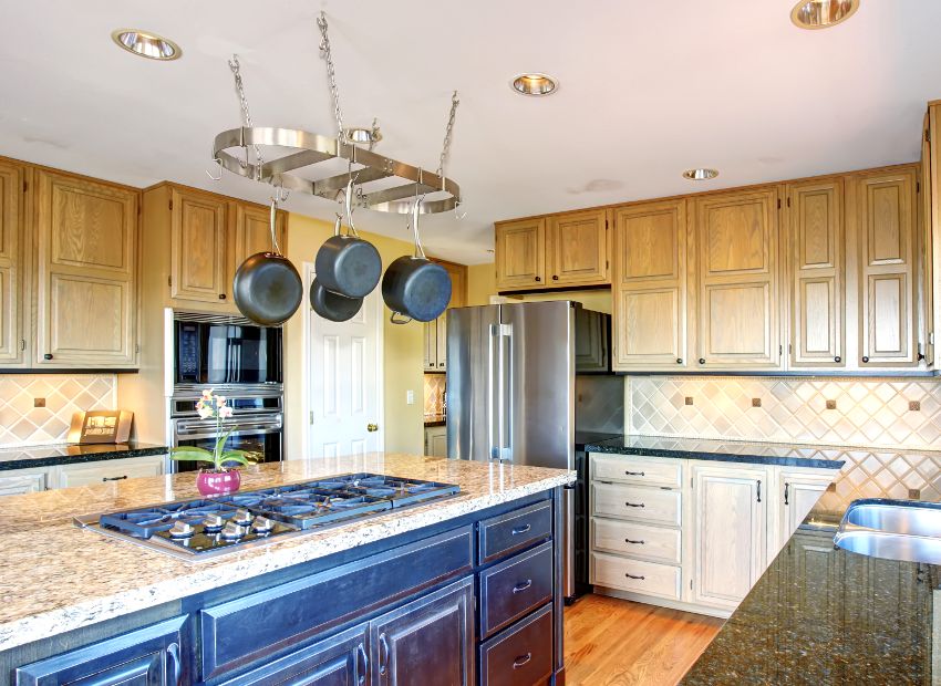 Traditional kitchen with pot hanger on top of island, granite countertops and quarter sawn white oak cabinets