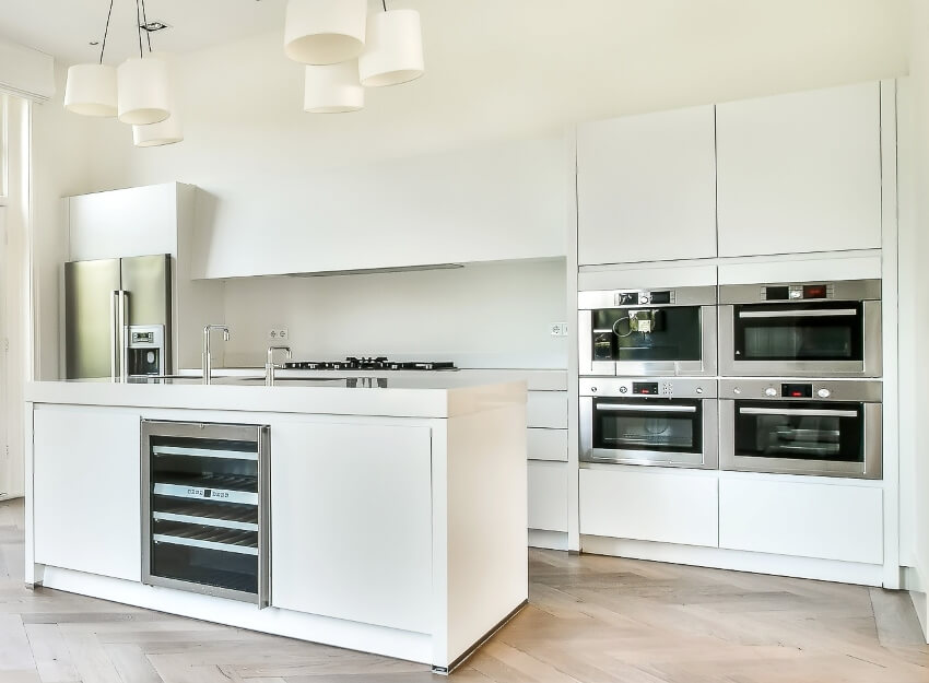 White kitchen with island, ready to assemble cabinets, built in ovens and fridge