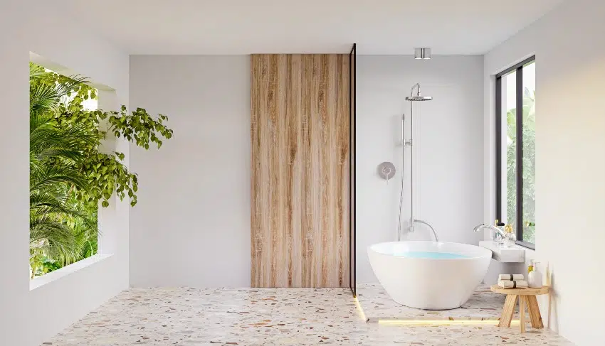White bathroom with wooden wall accent and a freestanding bathtub