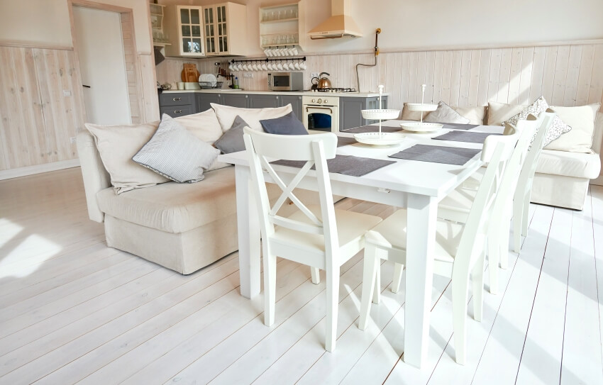 White kitchen with white furniture, grey cabinets, painted plywood floors and wall planks